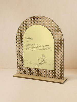 Ξύλινο επιτραπέζιο διακοσμητικό με μοτίβο rattan και καθρέπτη χρυσού χρώματος και χαραγμένος ο ορισμός του skiing και φιγούρα σκιέρ.