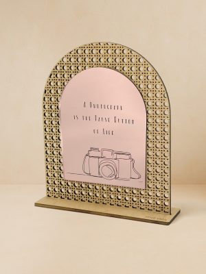 Ξύλινο επιτραπέζιο διακοσμητικό με μοτίβο rattan και καθρέπτη χρυσού χρώματος, χαραγμένη vintage κάμερα και φράση «A photograph is the pause button of life».