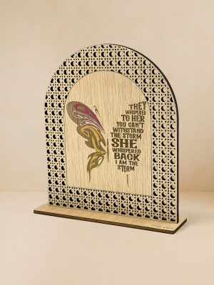 Ξύλινο επιτραπέζιο διακοσμητικό με μοτίβο rattan και χαραγμένη πολύχρωμη πεταλούδα και φράση ενδυνάμωσης «They whispered to her… I am the storm».