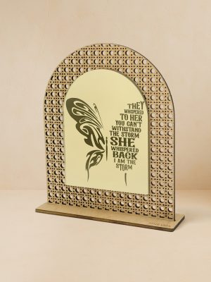 Ξύλινο επιτραπέζιο διακοσμητικό με μοτίβο rattan και καθρέπτη χρυσού χρώματος, χαραγμένη πολύχρωμη πεταλούδα και φράση ενδυνάμωσης «They whispered to her… I am the storm».