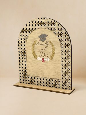 Ξύλινο επιτραπέζιο διακοσμητικό με μοτίβο rattan και καθρέπτη χρυσού χρώματος, χαραγμένα mortar board, στεφάνι δάφνης, δίπλωμα, τη φράση «Actually, it’s Dr.» και κενό χώρο για εξατομικευμένο όνομα. Ξύλινο επιτραπέζιο διακοσμητικό με μοτίβο rattan και καθρέπτη χρυσού χρώματος, χαραγμένα mortar board, στεφάνι δάφνης, δίπλωμα και φράση «Actually, it’s Dr.».
