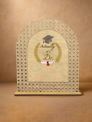 Ξύλινο επιτραπέζιο διακοσμητικό με μοτίβο rattan και καθρέπτη χρυσού χρώματος, χαραγμένα mortar board, στεφάνι δάφνης, δίπλωμα, τη φράση «Actually, it’s Dr.» και κενό χώρο για εξατομικευμένο όνομα. Ξύλινο επιτραπέζιο διακοσμητικό με μοτίβο rattan και καθρέπτη χρυσού χρώματος, χαραγμένα mortar board, στεφάνι δάφνης, δίπλωμα και φράση «Actually, it’s Dr.».