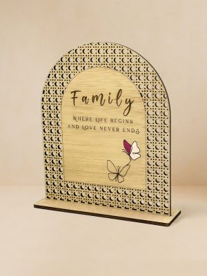 Ξύλινο επιτραπέζιο διακοσμητικό με μοτίβο rattan, που φέρει τη φράση «Family – where life begins and love never ends» και σχέδιο πεταλούδας.