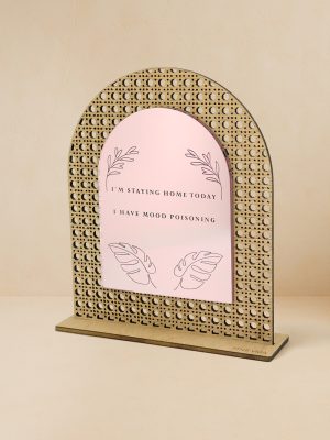 Ξύλινο επιτραπέζιο διακοσμητικό με μοτίβο rattan και καθρέπτη, χαραγμένη φράση «Σήμερα μένω σπίτι, έχω δηλητηρίαση τοξική διάθεση» με βοτανικά μοτίβα.