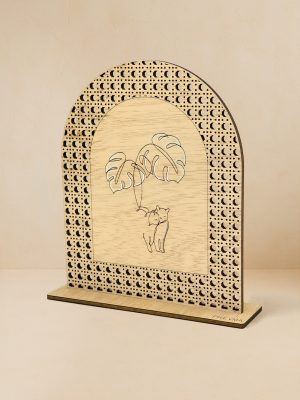 Ξύλινο επιτραπέζιο διακοσμητικό με μοτίβο rattan, όπου χαράζεται γάτα που παίζει με φύλλο μονστέρα.