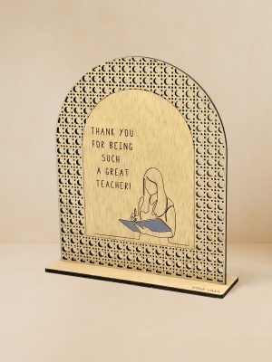Ξύλινο επιτραπέζιο διακοσμητικό με μοτίβο rattan και χαραγμένο μήνυμα ευχαριστίας στην δασκάλα, σε ουδέτερο φόντο.