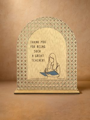 Ξύλινο επιτραπέζιο διακοσμητικό με μοτίβο rattan και χαραγμένο μήνυμα ευχαριστίας στην δασκάλα, σε ουδέτερο φόντο.