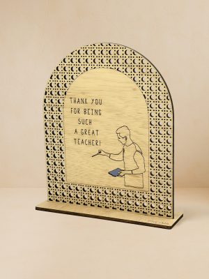 Ξύλινο επιτραπέζιο διακοσμητικό με μοτίβο rattan και χαραγμένο μήνυμα ευχαριστίας στον δάσκαλο, σε ουδέτερο φόντο.