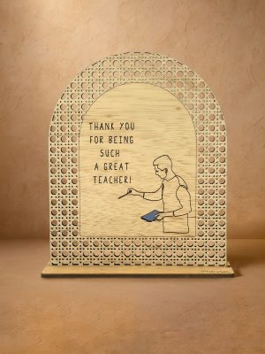 Ξύλινο επιτραπέζιο διακοσμητικό με μοτίβο rattan και χαραγμένο μήνυμα ευχαριστίας στον δάσκαλο, σε ουδέτερο φόντο.
