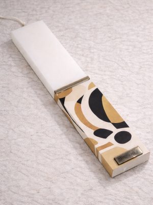 Λευκή λαμπάδα 25x4.5 με εκτύπωση MCM | αφαιρετικές καμπύλες σε μαύρο χρυσό και εκρού | σήμα Pnevma σε χρυσό.