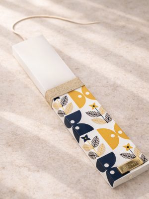 Λευκή λαμπάδα 25x4.5 με εκτύπωση Bau Grid σε navy και κίτρινο | γεωμετρικό μοτίβο με φύλλα | σήμα Pnevma σε χρυσό.