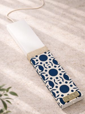 Λευκή λαμπάδα 25x4.5 με εκτύπωση Bau Grid | μπλε κύκλοι και μικρά φυτικά μοτίβα σε εκρού φόντο | σήμα Pnevma σε χρυσό.