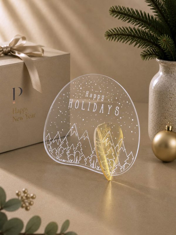 Γούρι Aurora Happy Holidays με γραμμικό γιορτινό χωριό, ορεινό ορίζοντα και καθαρή λευκή γραμμή.