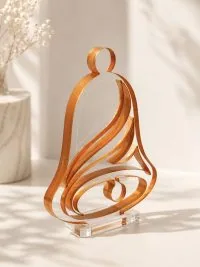 Γούρι Armonia Bell με κεχριμπαρένια σπείρα, ρευστές καμπύλες και λιτή γιορτινή γραμμή.