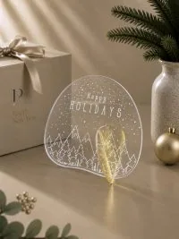Γούρι Aurora Happy Holidays με γραμμικό γιορτινό χωριό, ορεινό ορίζοντα και καθαρή λευκή γραμμή.