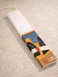 Λευκή λαμπάδα 25x4.5 με εκτύπωση MCM | color blocks σε ώχρα μπλε και εκρού με υφή | σήμα Pnevma σε χρυσό.