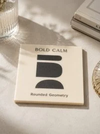 Κρεμ σουβέρ Bold Calm με μαύρα γεωμετρικά σχήματα και την επιγραφή Rounded Geometry.